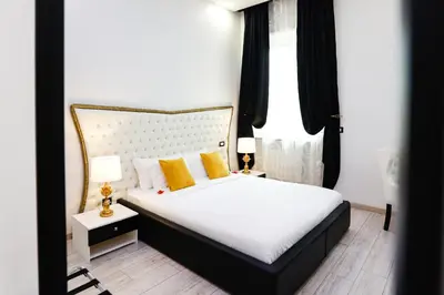 a bedroom with a white bed with yellow pillows at Escape Luxury Suite - CA Domus Collection in Rome