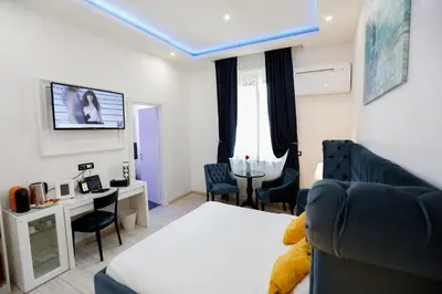a bedroom with a bed and a couch and a tv at Escape Luxury Suite - CA Domus Collection in Rome