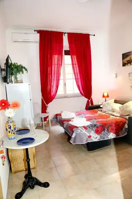 a table with two glasses of wine and a vase with flowers at Gateway Residence in Rome