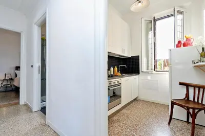 a kitchen with white cabinets and a white refrigerator at Piazza Capponi Apartment in Rome