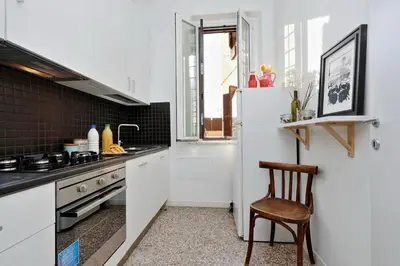 a kitchen with a refrigerator and a chair in it at Piazza Capponi Apartment in Rome
