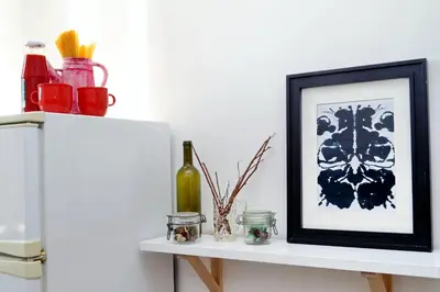 a white shelf with a picture and a bottle on it at Piazza Capponi Apartment in Rome
