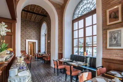 a restaurant with tables and chairs and windows at Hotel Damaso in Rome