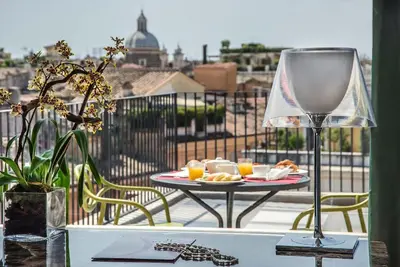 a table with a plate of food on a balcony at Hotel Damaso in Rome