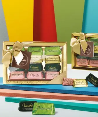a display of different types of chocolates in wooden boxes at Hotel Damaso in Rome