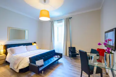 a bedroom with a blue bed and a table and chairs at RHS Rienzo Suites in Rome