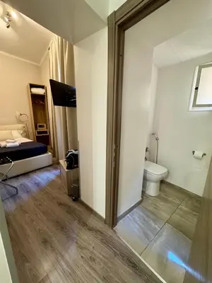 a room with a bathroom with a toilet and a bed at RHS Rienzo Suites in Rome
