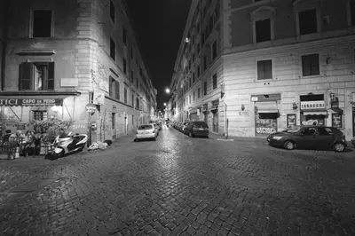 a black and white photo of a city street at night at stars luxury apartments in Rome