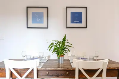 a dining room with a wooden table and white chairs at Spacious Apartment with Big Terrace at Colosseum in Rome