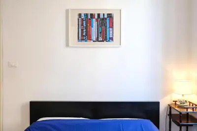 a bedroom with a bed and a picture of books at Spacious Apartment with Big Terrace at Colosseum in Rome