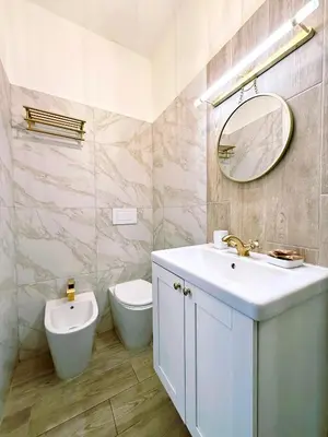 a bathroom with a sink and a toilet and a mirror at San Pietro Rooms 84 in Rome