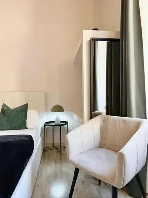a bedroom with a bed and a chair and a window at San Pietro Rooms 84 in Rome