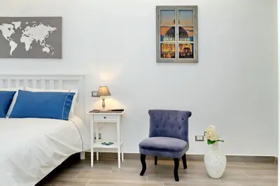 a bedroom with a bed and a blue chair at La Finestra sul Vaticano in Rome