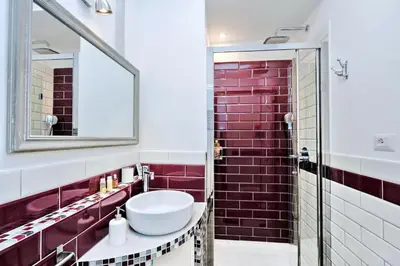a bathroom with a sink and a red brick wall at La Finestra sul Vaticano in Rome