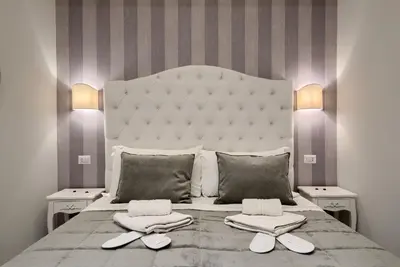 a bedroom with a large white bed with two night stands at Relais Vatican Secret in Rome