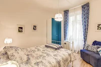 a bedroom with a bed and a couch and a window at Navona Flat di Elena & Paola in Rome