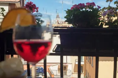 a glass of wine with a view of a city at Lago Terrione Apartment - Charme Holidays in Rome