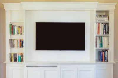 a flat screen tv on a wall with books at Rental in Rome - Fontana Di Trevi Penthouse in Rome