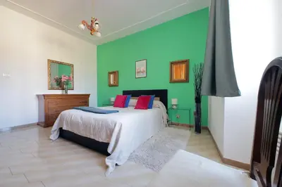 a bedroom with a bed and a green wall at Casa Rossi Roma in Rome
