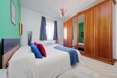 a bedroom with a large bed with blue and red pillows at Casa Rossi Roma in Rome
