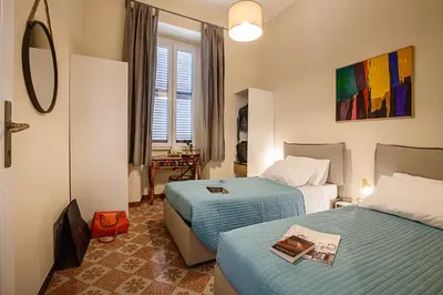 a hotel room with two beds and a window at RomaAmor in Rome