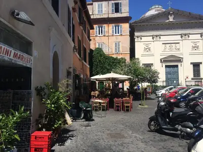 a street with tables and chairs and an umbrella at Moroni Trastevere Cozy Apartment in Rome