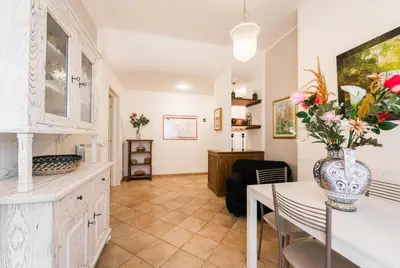 a living room with a table and a vase of flowers at Maison Velia San Giovanni in Rome