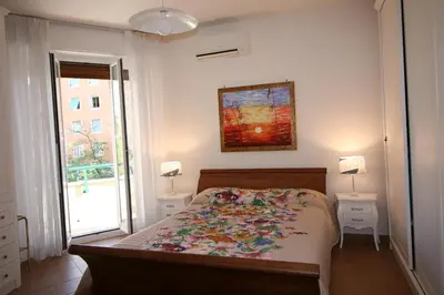 a bedroom with a bed and two lamps and a window at Maison Velia San Giovanni in Rome