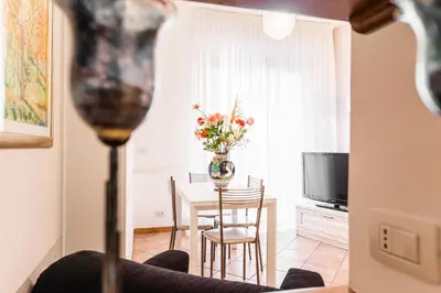 a living room with a table with a vase of flowers at Maison Velia San Giovanni in Rome