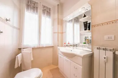 a bathroom with a sink and a toilet and a window at Maison Velia San Giovanni in Rome