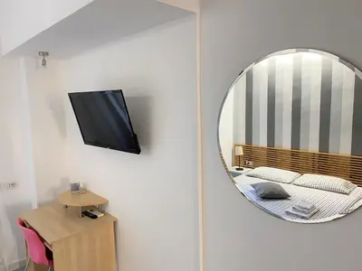 a mirror in a room with a bed and a television at St Peter Rooms in Rome