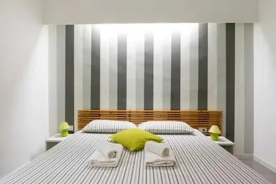 a bedroom with a bed with a yellow pillow on it at St Peter Rooms in Rome