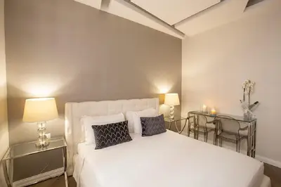 a bedroom with a white bed and two tables at Spagna Boutique in Rome