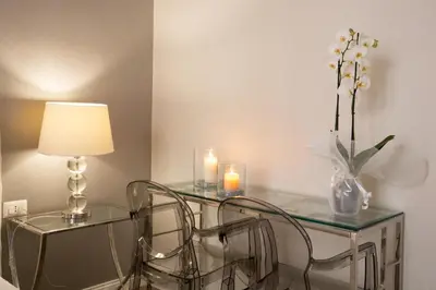 a glass table with candles and a vase with flowers at Spagna Boutique in Rome