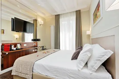 a hotel room with a bed and a flat screen tv at Piazza Venezia Grand Suite in Rome