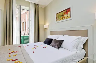 a bedroom with a large white bed with a window at Piazza Venezia Grand Suite in Rome