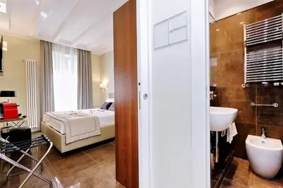 a bedroom with a bed and a bathroom with a sink at Piazza Venezia Grand Suite in Rome