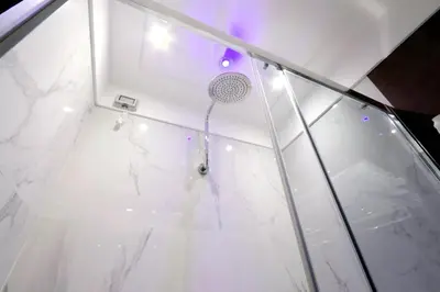 a shower with a glass door with a shower head at Piazza Venezia Grand Suite in Rome