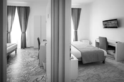 a hotel room with a bed and a desk and a bed and a desk at Vinci House in Rome
