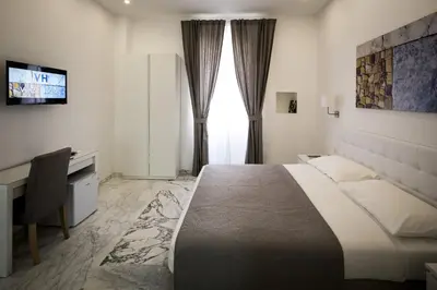 a bedroom with a bed and a desk and a television at Vinci House in Rome