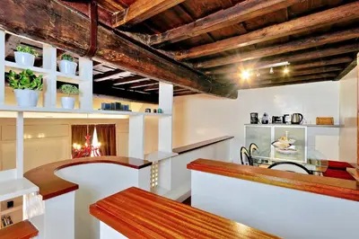a kitchen with wooden ceilings and a dining table at Pantheon Family Junior Suite in Rome