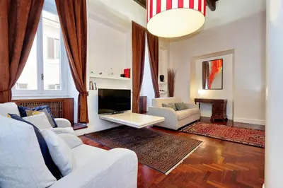 a living room with a white couch and a tv at Pantheon Family Junior Suite in Rome