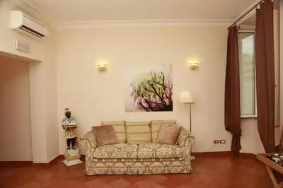 a living room with a couch and a painting on the wall at Residenza Gens Julia in Rome