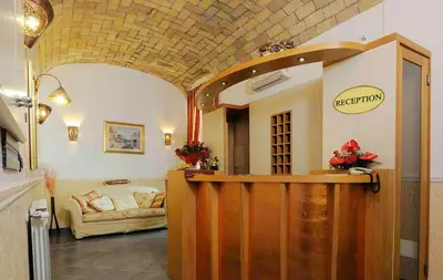 a lobby with a reception desk and a couch at Hotel Campidoglio in Rome