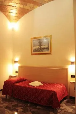 a bedroom with a bed with a red blanket at Hotel Campidoglio in Rome
