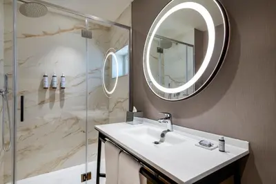 a bathroom with a sink and a shower with a mirror at AC Hotel by Marriott Clodio Roma in Rome