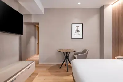 a living room with a table and a chair at AC Hotel by Marriott Clodio Roma in Rome