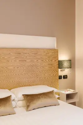 a bedroom with a white bed with a wooden headboard at Etruska luxury Trastevere Guesthouse in Rome