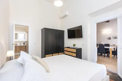 a bedroom with a white bed and a dining room at Rental in Rome - Bramante Luxury in Rome