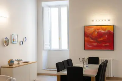 a dining room with a table and a painting on the wall at Rental in Rome - Bramante Luxury in Rome